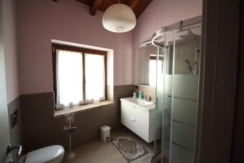 a bathroom with a sink and a toilet and a window at La Ca' Tòrta - Rustico ristrutturato in Neviano degli Arduini