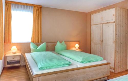 a bedroom with a bed with green pillows and a window at Amazing Home In Eichigt-ot Sssebach With 2 Bedrooms And Internet in Eichigt