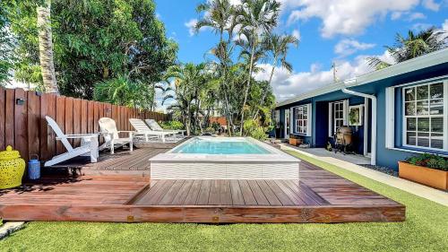 een achtertuin met een houten terras en een zwembad bij Modern Oasis in Fort Lauderdale