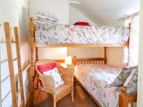 a bedroom with a bunk bed and two chairs at The Old Post Office in Colwyn Bay