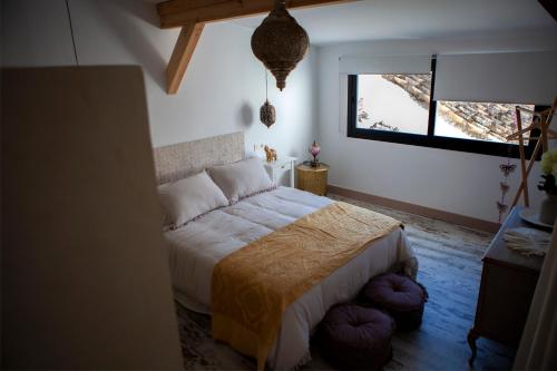 a bedroom with a bed and a window at Casas Rurales La Rinconá in Moral de Calatrava
