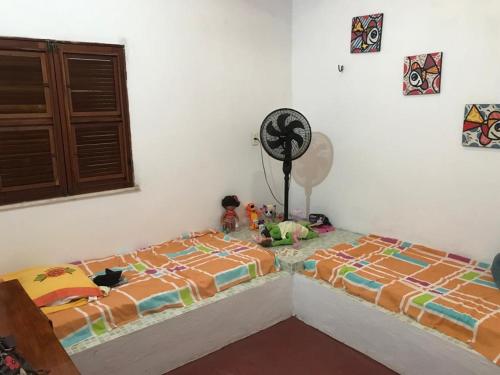 a bedroom with two beds and a clock on the wall at Baleia Beach - Casa de Praia in Itapipoca