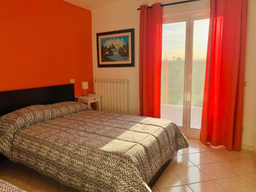 a bedroom with a bed with red curtains and a window at The House Fiera di Roma Aeroporto Fiumicino in Ponte Galeria