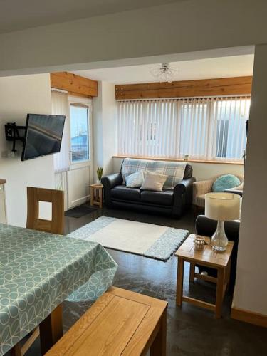 a living room with a bed and a couch at Cottage near Caernarfon, Gwynedd in Llanwnda