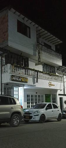 two cars parked in front of a building at night at Hotel Los Balcones in San Agustín