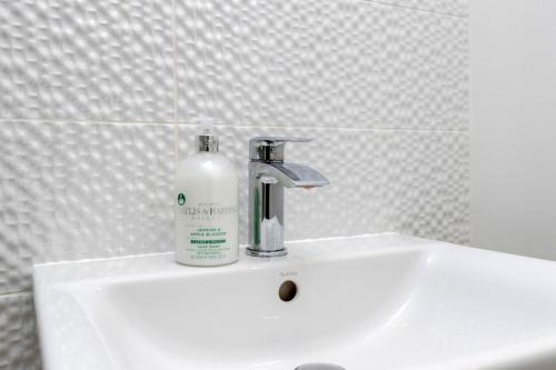- un lavabo blanc avec une bouteille de savon dans l'établissement 4 Bed 2 Bath Luxury Home in County Durham, à Chilton