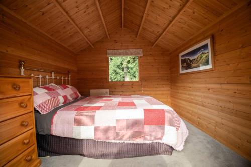 a bedroom with a bed in a wooden cabin at Tui Ridge Eco Cabins in Aongatete