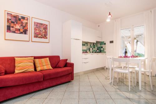 sala de estar con sofá rojo y mesa en Colibrì by SolturElba en Capoliveri