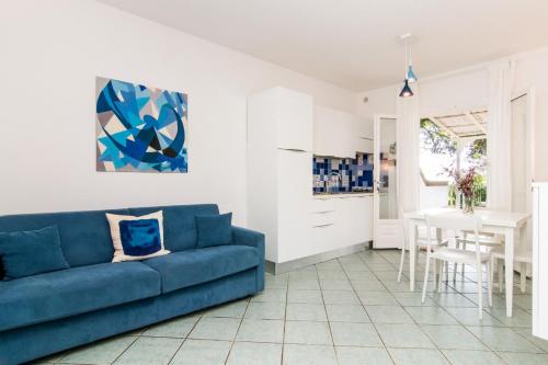uma sala de estar com um sofá azul e uma mesa em Colibrì by SolturElba em Capoliveri