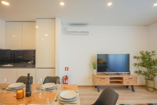 a dining room with a table and a television at Alameda 74 Luxury Apartment & Parking by Home Sweet Home Aveiro in Aveiro
