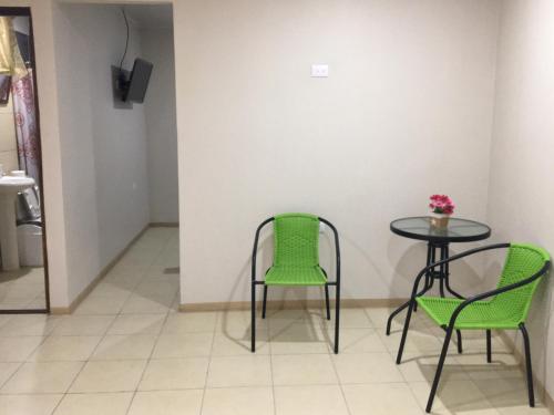 Rivera Family Apartments في Santiago Este: طاولة وكرسيين وطاولة عليها مزهرية