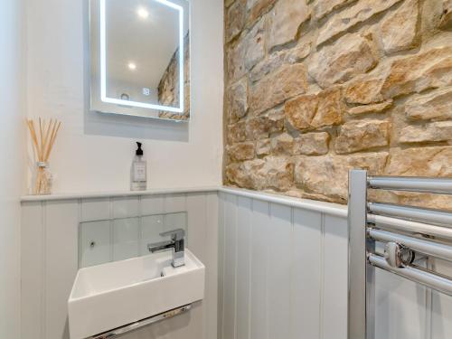 a bathroom with a sink and a stone wall at South View in Haydon Bridge