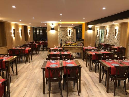 a restaurant with tables and chairs in a room at Hôtel Picheyre in Formiguères