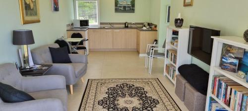 a living room with a couch and a tv at Hyecroft Lodge in Whangarei