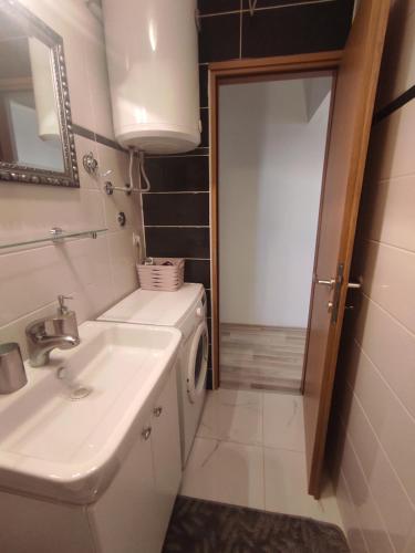 a bathroom with a sink and a washing machine at Apartments Emi & Nini in Šibenik