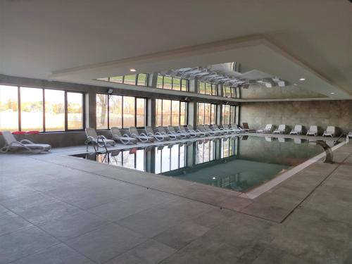 a swimming pool in a building with chairs around it at Marina View 15 & SPA in Dziwnów