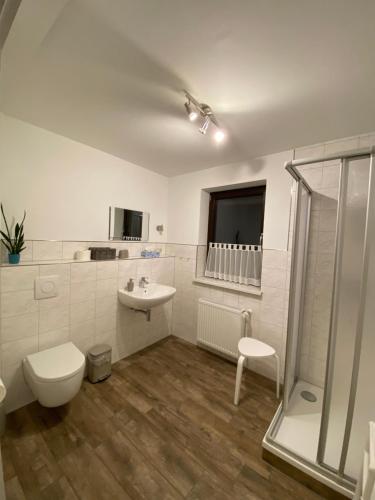 ein Bad mit einem WC, einem Waschbecken und einer Dusche in der Unterkunft Pension Haufe in Ohorn