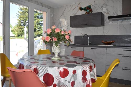 eine Küche mit einem Tisch und einer Blumenvase darauf in der Unterkunft Gîte Au Clair Matin ,la Mure, les passerelles Monteynard in Pierre-Châtel