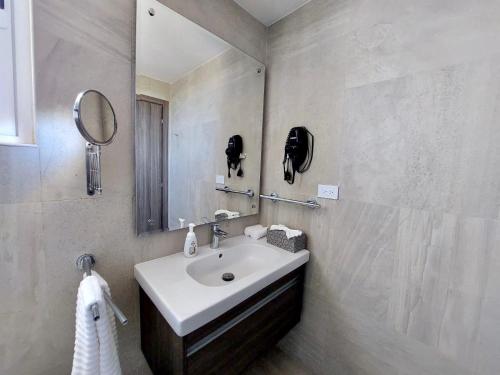 a bathroom with a sink and a mirror at Unique Pool & Golf view retreat 1BR in Hard Rock in Punta Cana