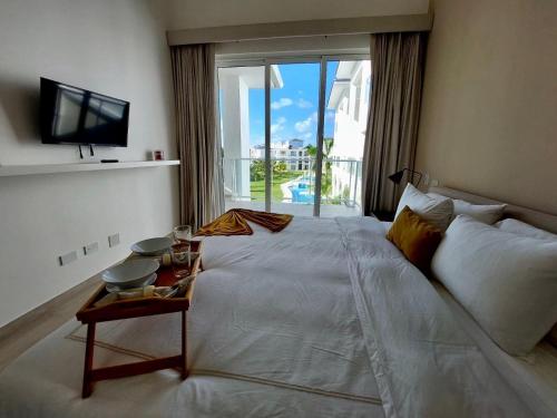 a bedroom with a large bed and a large window at Unique Pool & Golf view retreat 1BR in Hard Rock in Punta Cana