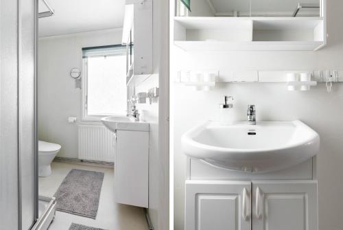 a white bathroom with a sink and a toilet at Authentic Swedish family home on the archipelago in Stavsnäs