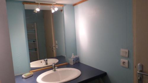 a bathroom with two sinks and a large mirror at Residence des Ondines in Damgan