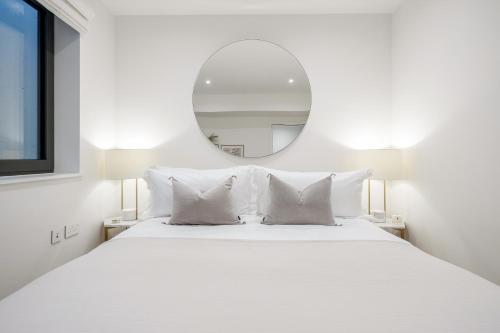 um quarto branco com uma grande cama branca e um espelho em Luxury Central Mayfair Townhouse with AC 3BR 3BA em Londres