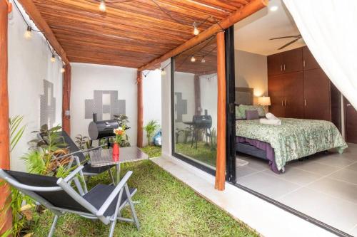 een slaapkamer met een bed, een tafel en een stoel bij My happy place in Tulum