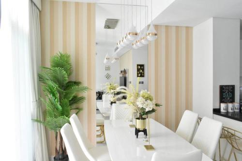 a dining room with a white table and white chairs at Exquisite Home with Smart Office in Dubai