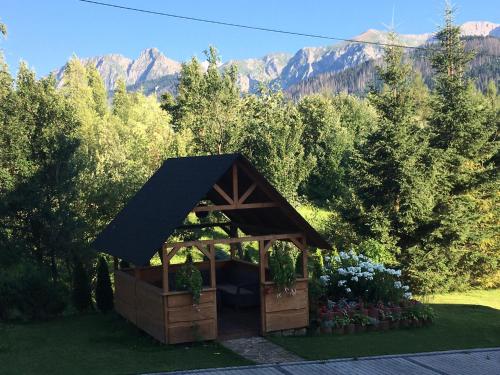 a gazebo in a garden with mountains in the background at Willa Królewska - Wellness SPA - widokowe Pokoje i Apartamenty in Kościelisko