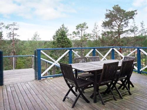 een houten tafel en stoelen op een houten terras bij 7 person holiday home in INGAR in Hanskroka