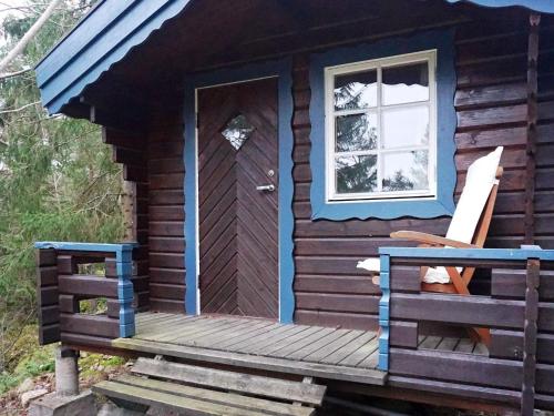 een blokhut met een houten veranda en een deur bij 7 person holiday home in INGAR in Hanskroka
