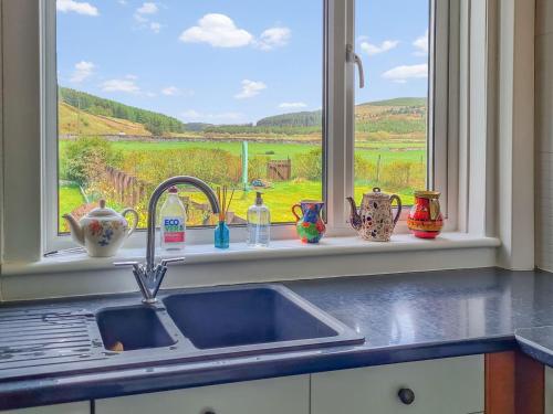 a kitchen counter with a sink and a window at Craik Forestry Cottage in Teviothead