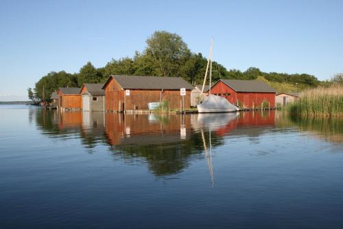 a body of water with houses and a boat in it at Villa Seeschwalbe Plau in Plau am See