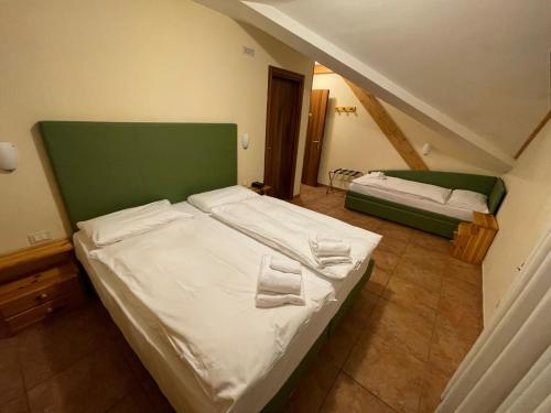 タルヴィージオにあるHotel Triesteのベッドルーム1室(ベッド2台、緑のヘッドボード付)