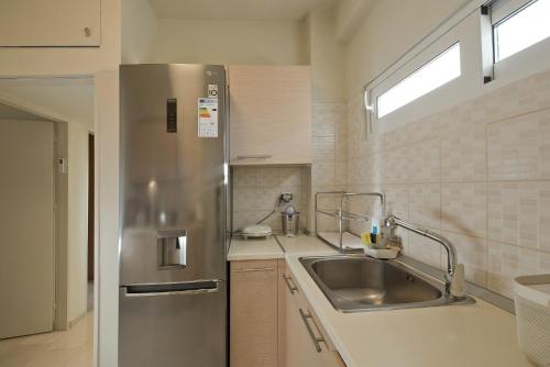 a kitchen with a stainless steel refrigerator and a sink at LucyZen in Athens