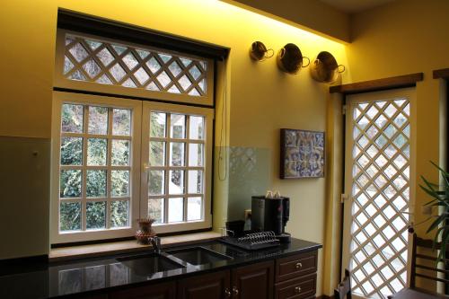 a kitchen with two windows and a sink at Camping Lamego Douro Valley in Lamego