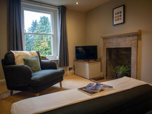 a living room with a chair and a fireplace at The Beeches - Chatsworth Apartment No 3 - Sleeps 2 in Baslow