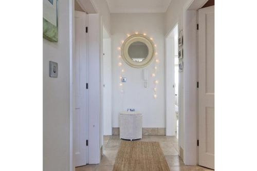 a hallway with white walls and a mirror at Pen Y Sarn in Abersoch