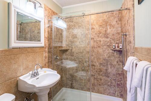 een badkamer met een wastafel en een douche bij Island Motel OBX in Manteo