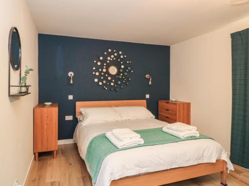 a bedroom with a large bed with a blue wall at Struthan in Valtos