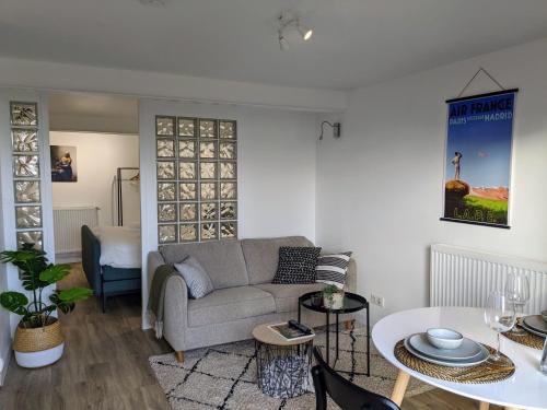 un salon avec un canapé et une table dans l'établissement Private studio with garden - Maison 1870, à Sarlat-la-Canéda