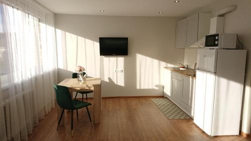 una cucina con tavolo, sedie e frigorifero di Stay in center #Šiauliai a Šiauliai