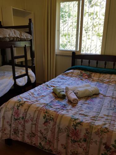 1 cama con 2 toallas y ventana en Casa Aurora en Cambara do Sul