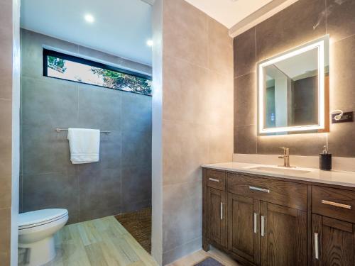 a bathroom with a toilet and a sink and a mirror at Newly Renovated 8 Bedroom Ocean Front Villa with Pool in Rio Grande