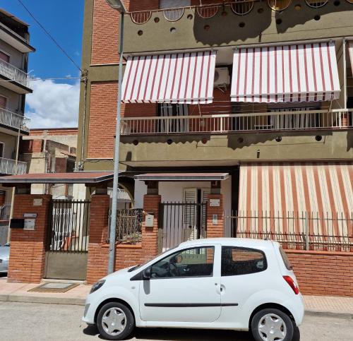 a white car parked in front of a building at Emy House in Gela