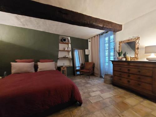 1 dormitorio con cama roja y pared verde en Maison de village Haut-de-Cagnes avec vue mer, en Cagnes-sur-Mer