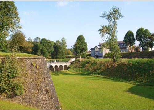 a bridge over a lush green field with a bridge at Appart confort#1, centre-ville, Gare à pieds proche commodités in Maubeuge