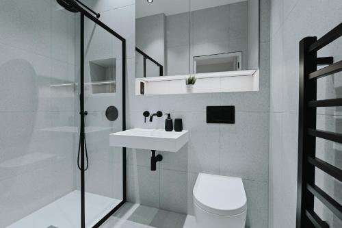 a bathroom with a toilet and a sink and a shower at Khayat Homes - Kings Cottage in London