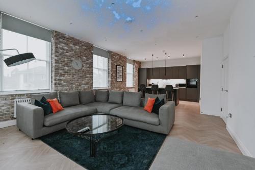 a living room with a couch and a table at Khayat Homes - Kings Cottage in London